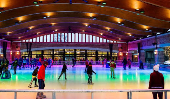 Visitors ice skating beneath colorful lights at Central Park Plaza’s covered outdoor ice rink in downtown Valparaiso, Indiana.